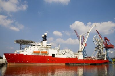 Construction vessel carrying cable-handling equipment at sea