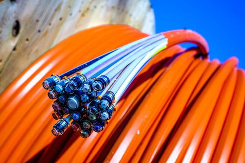 Close-up of orange fiber-optic cable wound on a drum