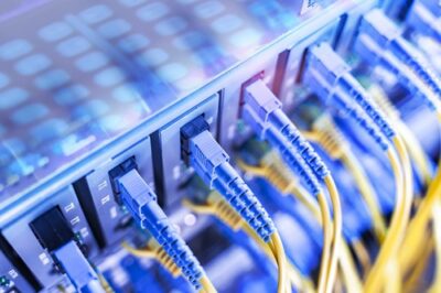 Fiber-optic network cables connected to data-center equipment, illustrating FLAG's AI-era network strategy
